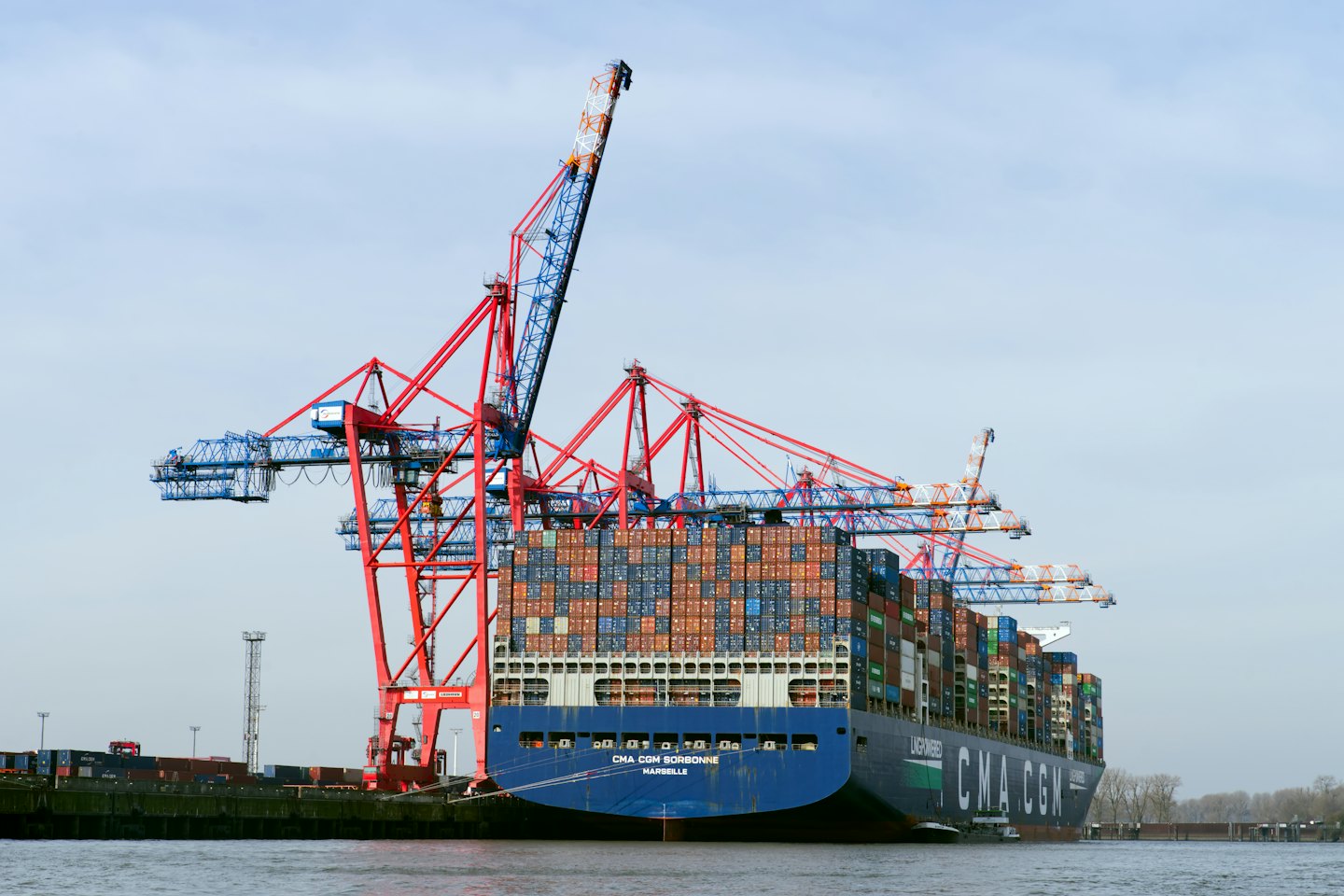 A large cargo ship loaded with containers docked at port.